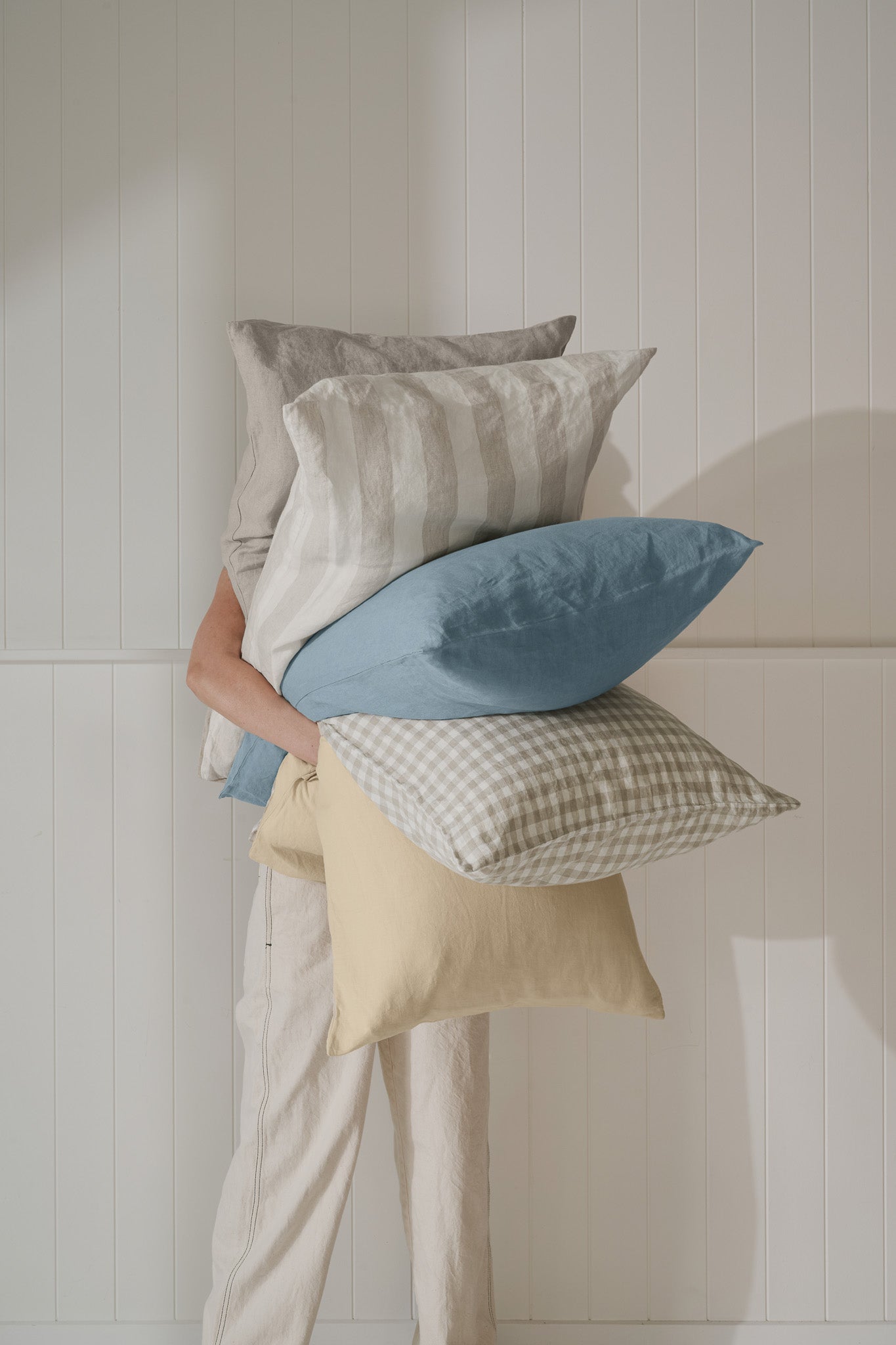 model holding 5 linen pillows
